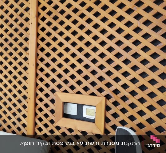 קיר עץ עם שקע חשמל וכיסא